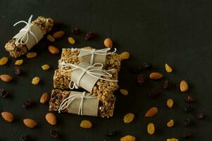 homemade granola energy bars with almond and raisins on black background. Healthy food photo