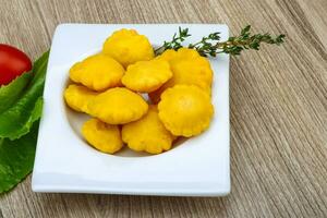 Pickled patissons in a bowl on wooden background photo