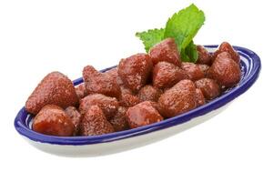 Marinated strawberry in a bowl on white background photo