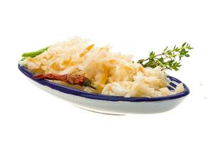 Fermented cabbage in a bowl on white background photo