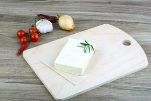 Cheese Brinza on wooden board and wooden background photo