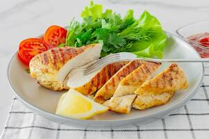 Grilled chicken breasts served on a plate with salad and vegetables. Dietary food photo