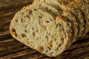 Gluten-free vegan bread and no animal products. Vegetarian bread with oatmeal, banana flavor, on a wooden rustic table, sliced and ready to serve. photo