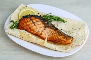 Grilled salmon on the plate and wooden background photo