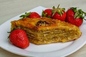 Baklava on the plate and wooden background photo