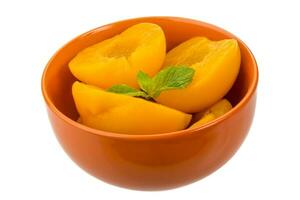 Marinated peaches in a bowl on white background photo
