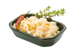 Fermented cabbage in a bowl on white background photo