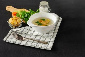 Homemade chicken bouillon or broth. healthy dinner. black concrete background. photo