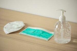 Medical face mask with alcohol sanitizer gel hand wash on wood table for covid-19 Coronavirus prevention concept photo