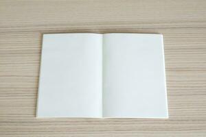 Mock up blank open paper book on wood table background