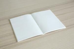 Mock up blank open paper book on wood table background photo