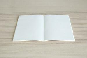 Mock up blank open paper book on wood table background photo