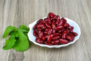 Kidney beans on the plate and wooden background photo