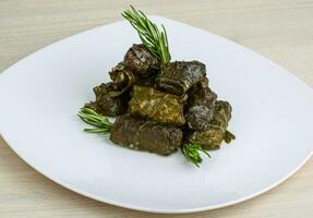 Dolma on the plate and wooden background photo