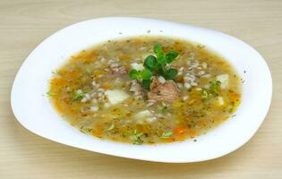 Cereal soup on the plate and wooden background photo