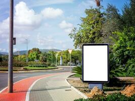 cartelera en blanco con espacio de copia para su mensaje de texto o contenido promocional. publicidad callejera simulacro de banner vacío cerca del parque y la carretera foto