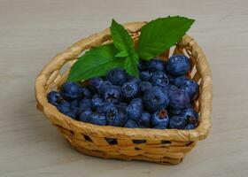 Blueberry in a basket on wooden background photo