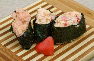 sushi gunkan sobre tablero de madera y fondo de madera foto