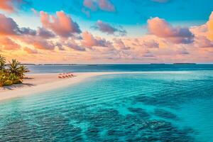 Aerial view of amazing beach, couple umbrellas, chairs beds close to sea lagoon. Fantastic sky clouds summer beach landscape. Idyllic nature for inspire tourism vacation, romantic holiday in Maldives photo