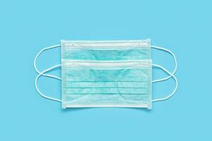 Surgical face mask on blue background protection against COVID-19 coronavirus. Healthcare and medical concept photo