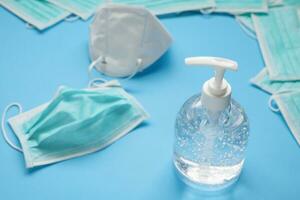 KN95 Medical face mask with alcohol sanitizer gel hand wash bottle on blue background covid-19 Coronavirus prevention concept photo
