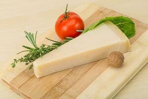 Parmesan cheese on wooden board and wooden background photo