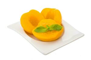 Marinated peaches in a bowl on white background photo