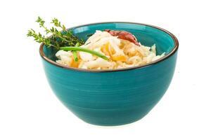 Fermented cabbage in a bowl on white background photo