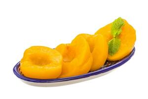 Marinated peaches in a bowl on white background photo