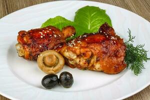 Teriyaki chicken on the plate and wooden background photo