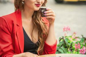 Beautiful girl having coffee at cafe outdoors. photo