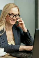 mujer joven está hablando por teléfono celular en la oficina. foto