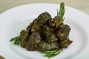 Dolma on the plate and wooden background photo