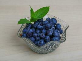 Blueberry in a bowl on wooden background photo