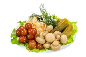 Verduras marinadas en el plato y fondo blanco. foto