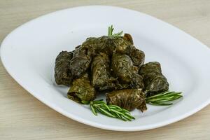 Dolma on the plate and wooden background photo