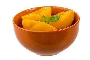 Marinated peaches in a bowl on white background photo