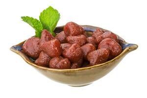 Marinated strawberry in a bowl on white background photo