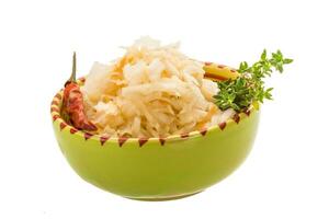 Fermented cabbage in a bowl on white background photo