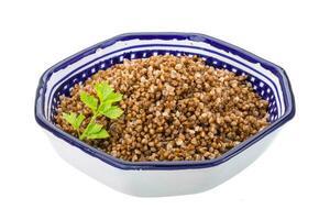 Buckwheat in a bowl on white background photo