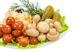 Verduras marinadas en el plato y fondo blanco. foto