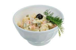 Russian salad in a bowl on white background photo