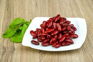Kidney beans on the plate and wooden background photo