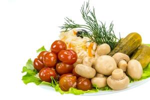 Verduras marinadas en el plato y fondo blanco. foto