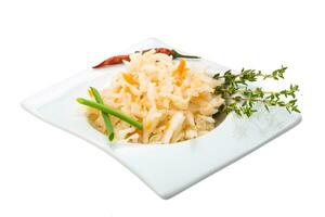 Fermented cabbage in a bowl on white background photo