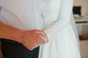 el padre toma la mano de la novia de su hija en el día de su boda. foto