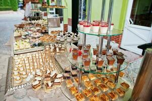 hermosa barra de dulces de boda con dulces, frutas y comida. mesa de banquete de boda foto