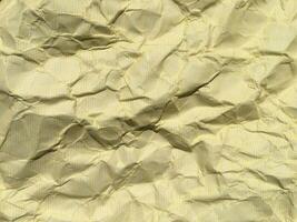 Yellow crumpled paper background with pattern for design photo