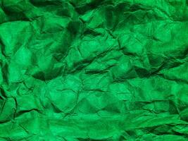 Closeup view of green crumpled paper texture background. photo