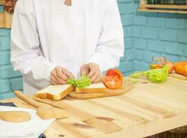 Asian woman in chef's uniform is cooking in the kitchen. photo